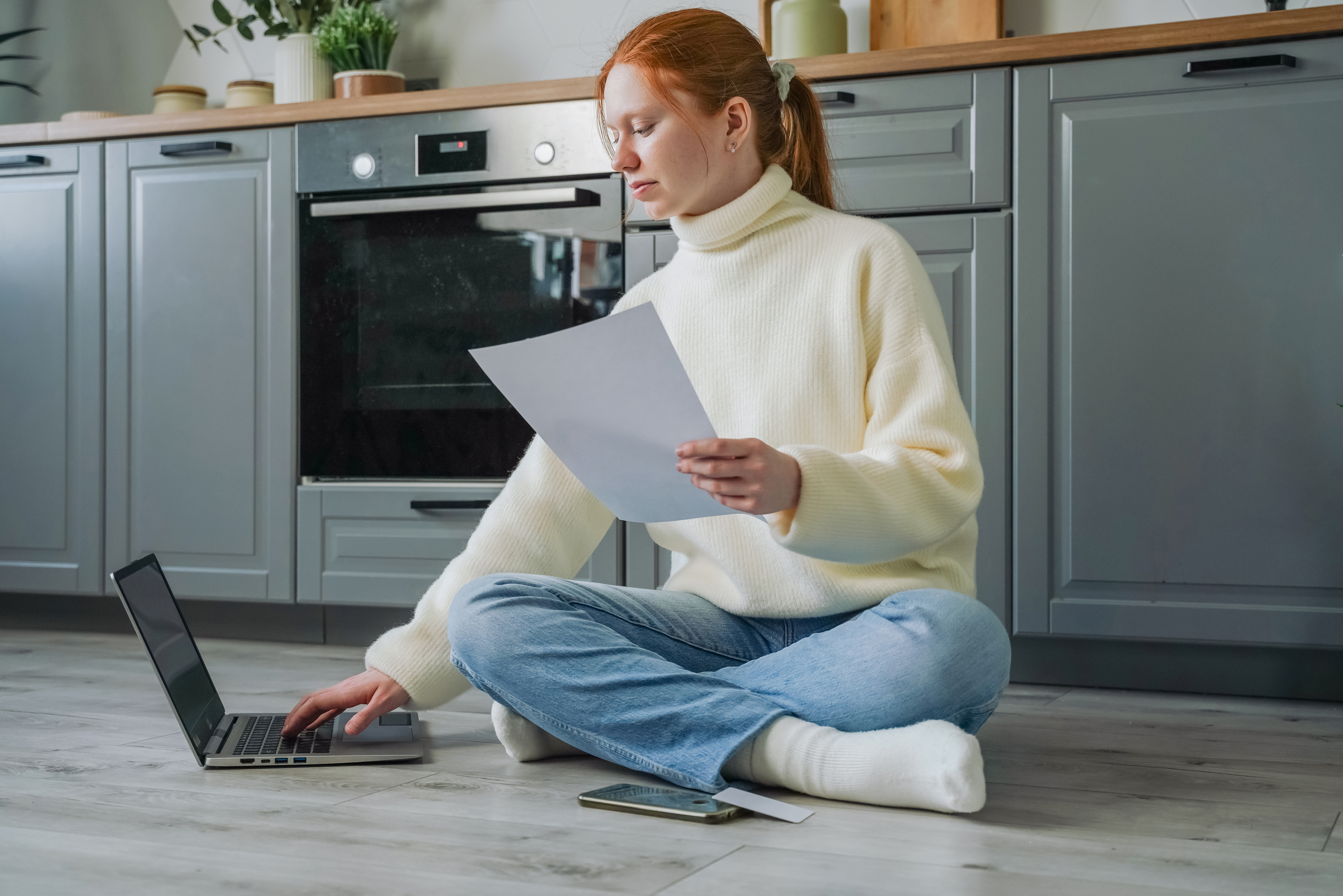 Searching for unfurnished rental apartments while seated on the kitchen floor