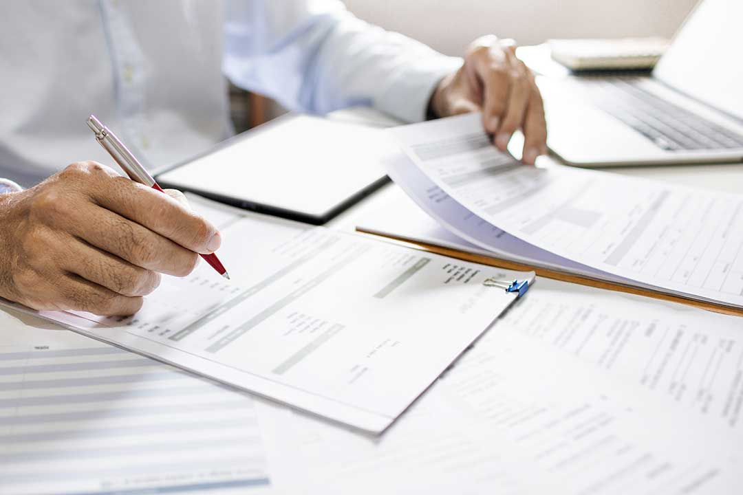 Attorney drafting and reviewing contract documents in a professional office