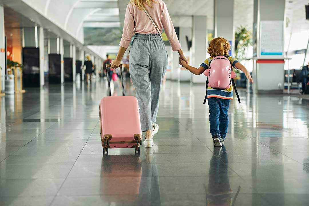 Parent and child walking together with luggage