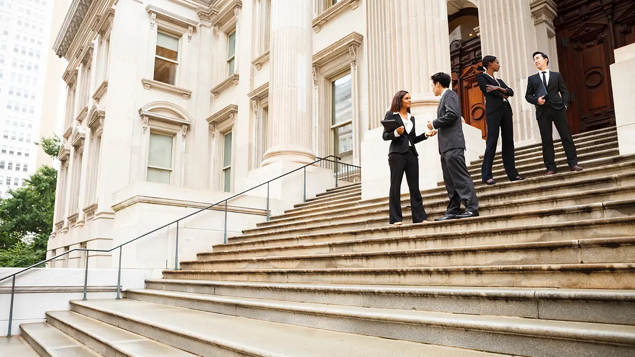 Lawyers discussing legal matters on courthouse steps – professional legal services by Heymann Fletcher Law Firm