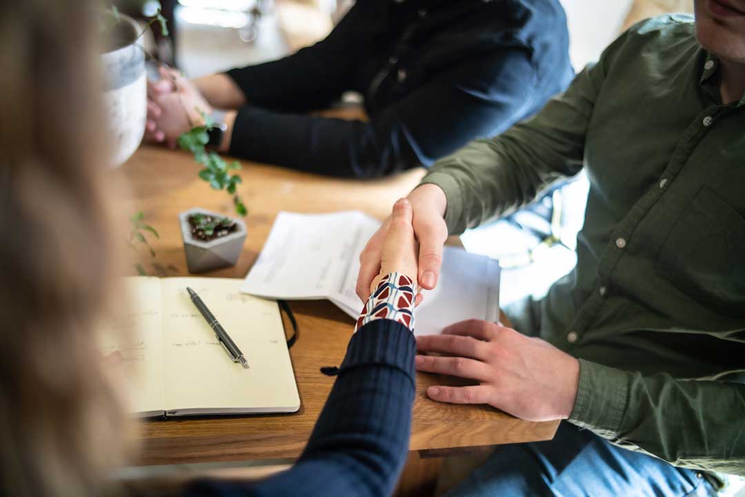 Divorce mediator facilitating a calm discussion between two adults at a table